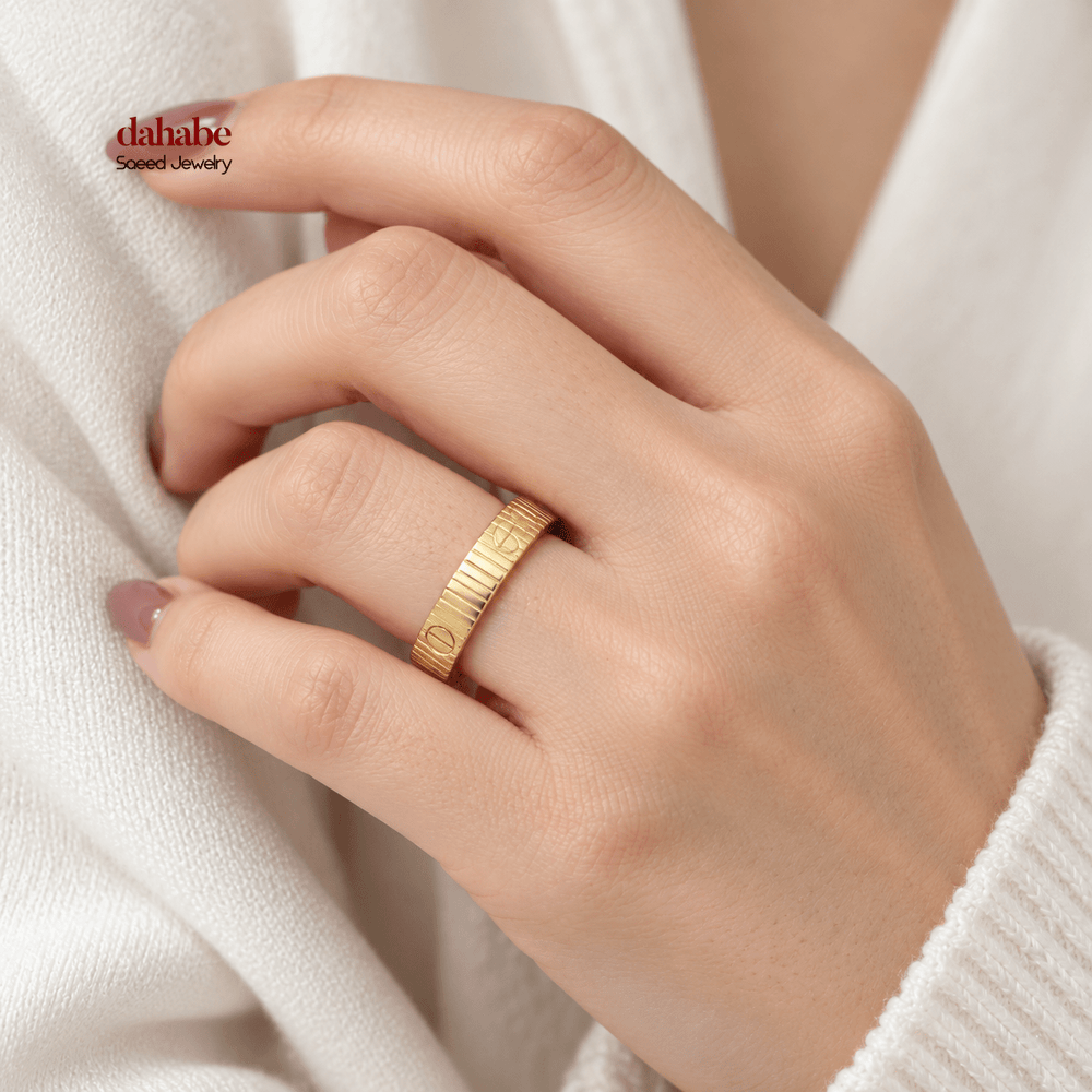 AI-generated try-on simulation of an 18K gold ring with vertical ridges and round screw motifs, shown on a woman's hand; US size 10.
