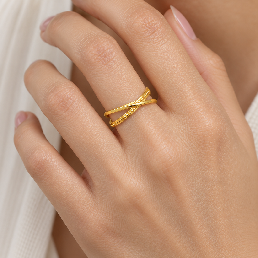 AI-generated try-on simulation of a 21K gold crossover ring with one beaded-edge band.